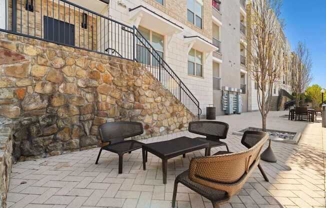 A patio with a table and chairs is in front of a building.