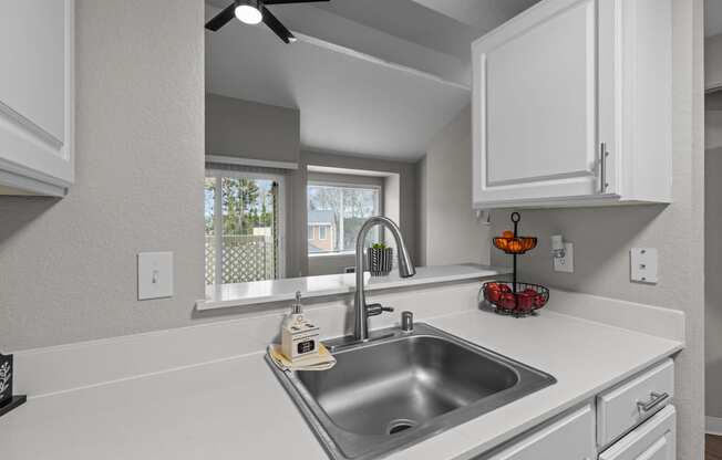 the kitchen of our studio apartment has a stainless steel sink and white cabinets