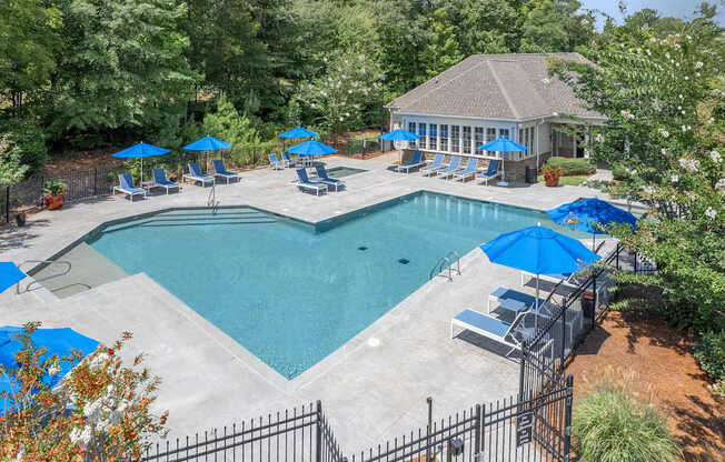 A pool surrounded by trees and a gazebo.