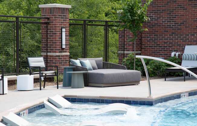 a swimming pool with a couch and chairs next to a pool