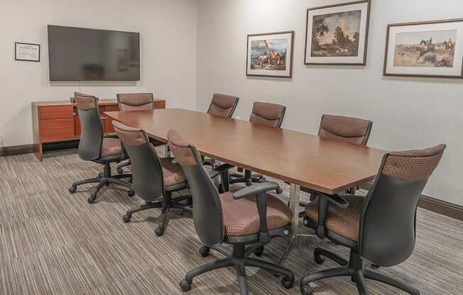A conference room with a long table and chairs.