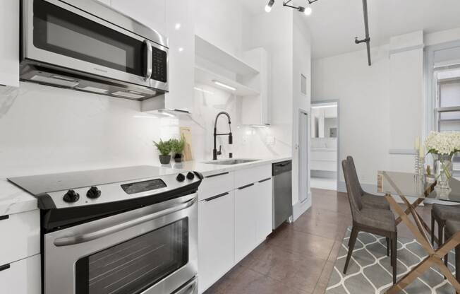 Downtown LA CA Lofts - Santa Fe Lofts - Designer Kitchen with White Cabinets, Marbled Countertops, and Stainless Steel Appliances.