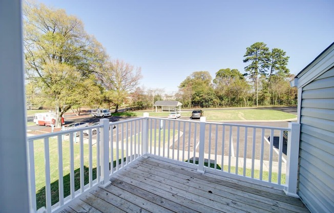 a view from the deck of a home with a baseball field in the background