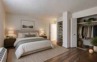 A bedroom with a large bed, a wardrobe, and a painting on the wall.