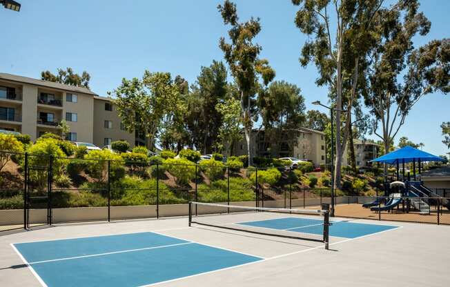 two tennis courts with apartments in the background