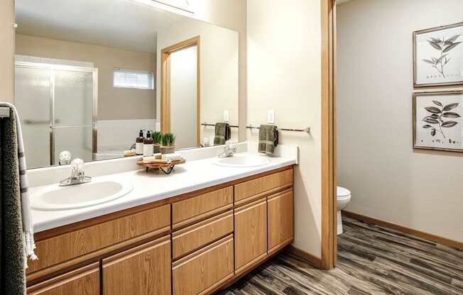 A bathroom with a wooden vanity and two sinks. at Tranquility Pointe, Nebraska