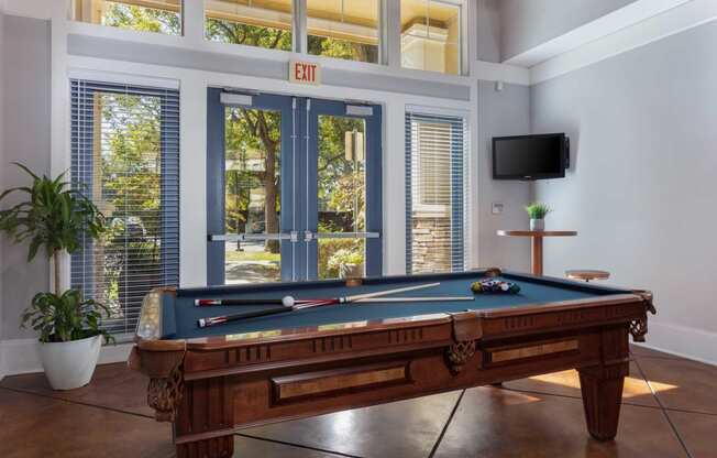 a pool table in a living room with a tv