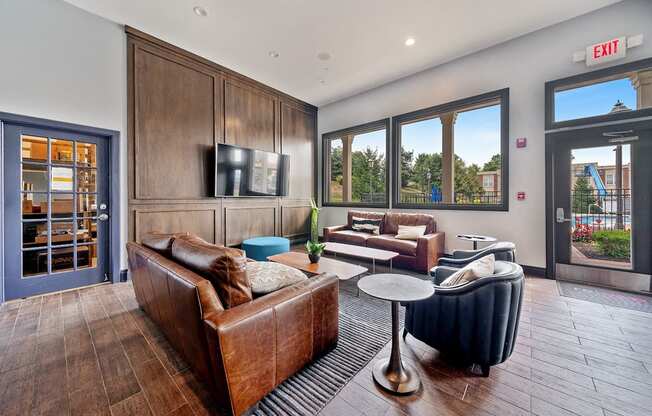 A living room with a brown couch and a television on the wall.