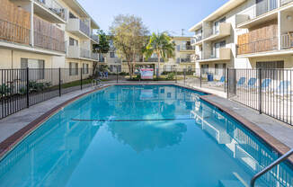 the swimming pool of an apartment building with a blue pool