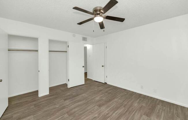 A room with a ceiling fan and wooden flooring at The Phoenix Apartments on 6th Avenue, Phoenix, AZ