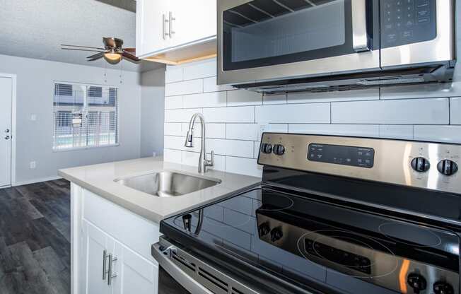 a kitchen with white cabinets and stainless steel appliances