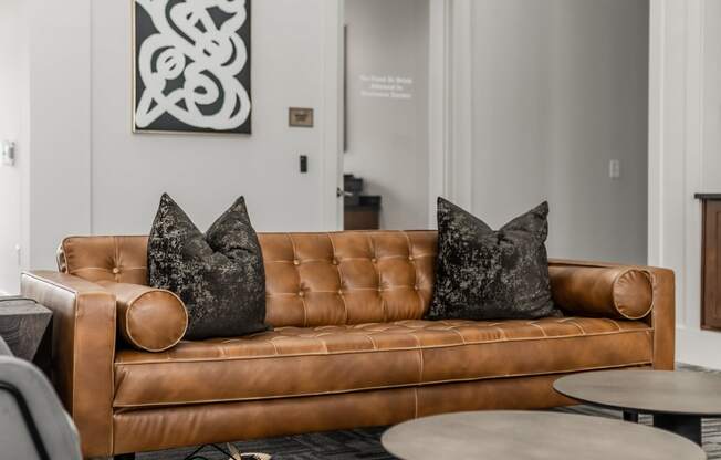 a living room with a brown couch and tables