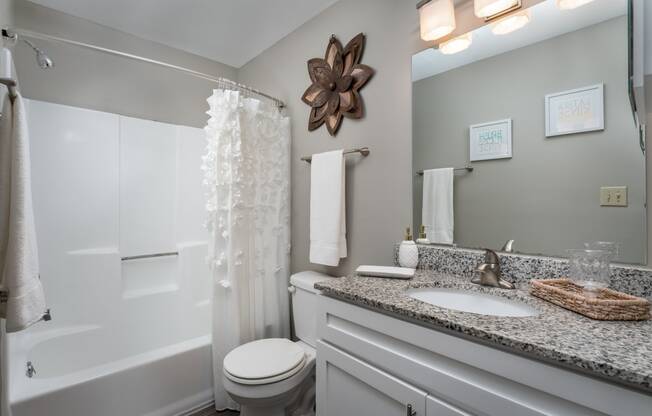 a bathroom with gray walls and a white shower curtain
