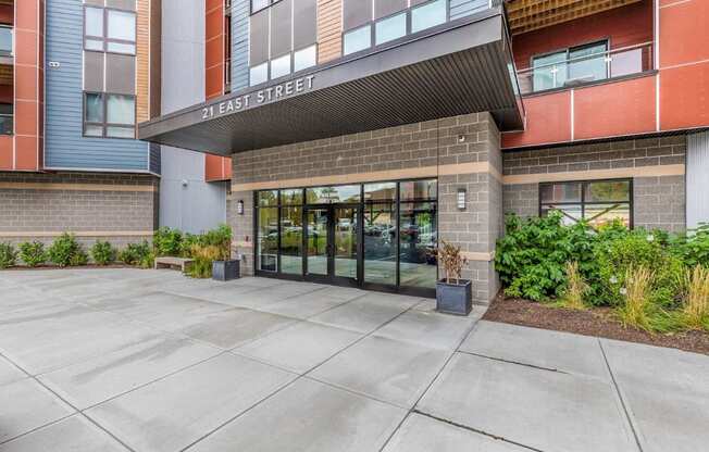 the entrance to a building with glass doors and a sidewalk
