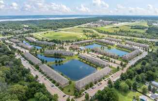 A bird's eye view of a residential area with a lake in the middle.