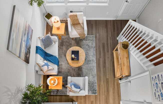 A living room with a couch, a coffee table, and a staircase.at Lofts of Wilmington, Wilmington, NC, 28405
