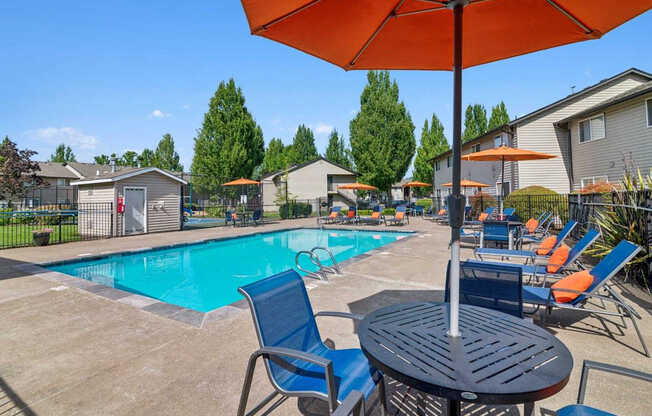 A sunny day at the pool with chairs and umbrellas.