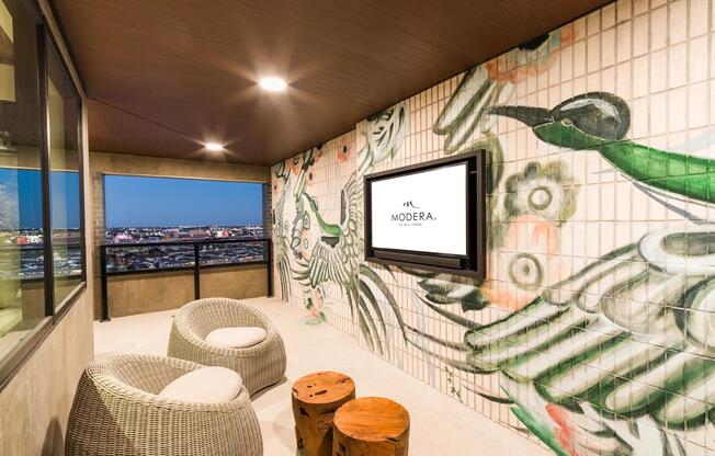 A cozy sky lounge with custom mural details and skyline views, offering a relaxed spot to unwind at Modera St. Paul.