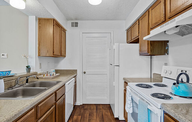 a kitchen with a stove sink and a refrigerator