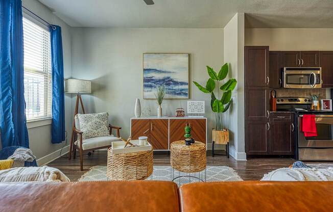 A living room with a brown couch and a painting on the wall.