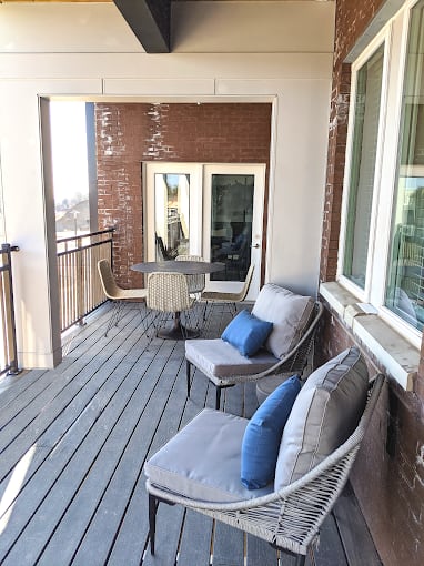 a balcony with two chairs and a table and a window