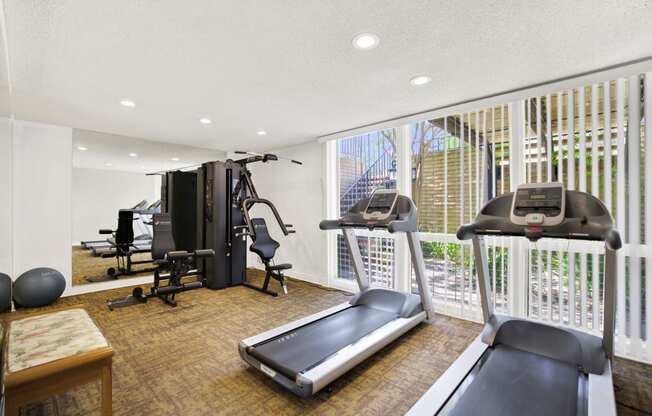 a gym with exercise equipment and a large window at Casa Del Amo Apartments, California, 90505