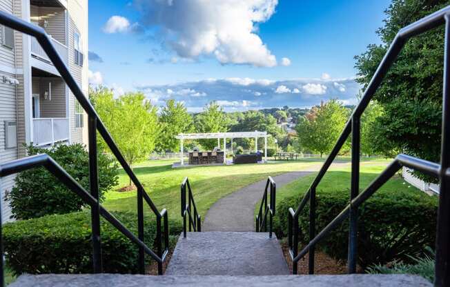 a view of a park with a gazebo in the distance from stairs