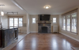 an empty living room with a fireplace and a tv