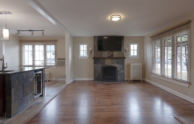 an empty living room with a fireplace and a tv