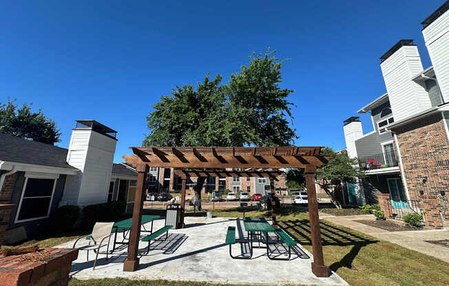 A patio with a table and chairs under a pergola.