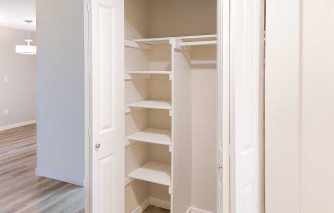 an empty room with an open closet with shelves
