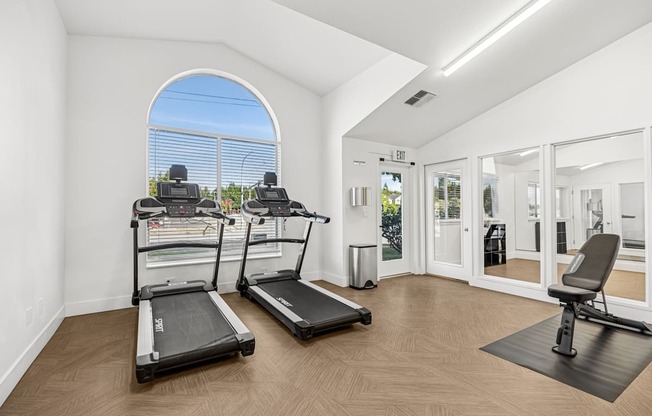 A room with treadmills and a stationary bike.