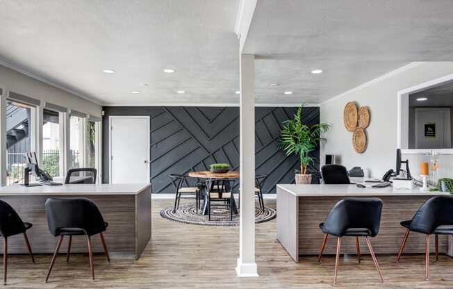 a room with a table and chairs in front of a wall with a black and white geometric