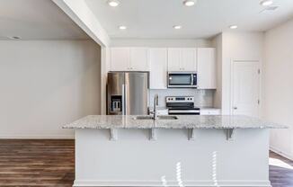 a kitchen with white cabinets and a granite counter top