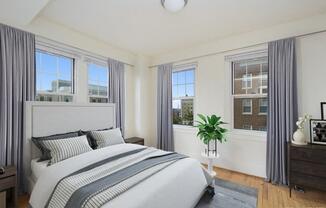 a bedroom with a bed and three windows