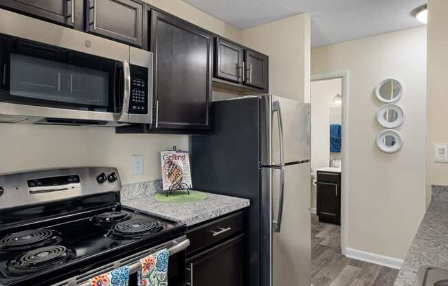 an updated kitchen with black appliances and stainless steel appliances