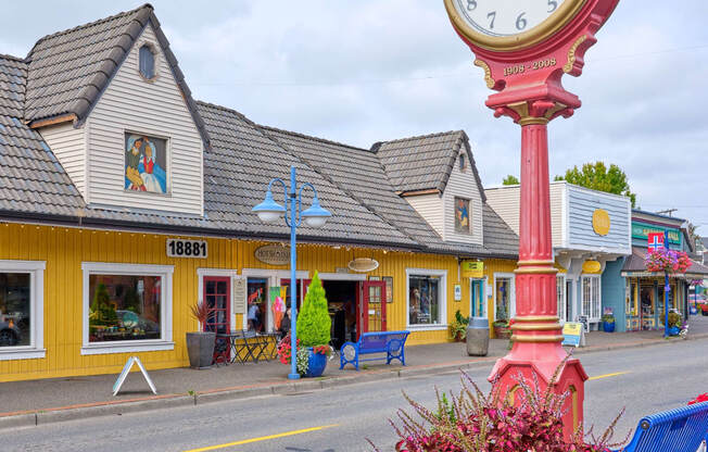 a large clock on the side of a street with a vase of flowers at Woodcreek, Washington, 98370