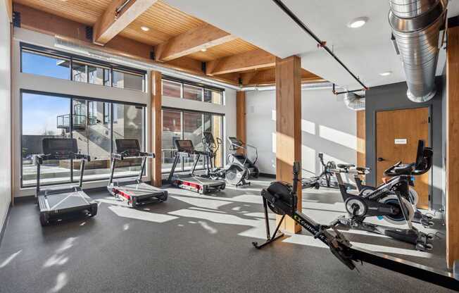 A gym with treadmills, exercise bikes and a rowing machine.