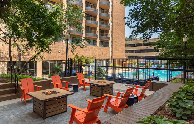 a patio with tables and chairs near a swimming pool