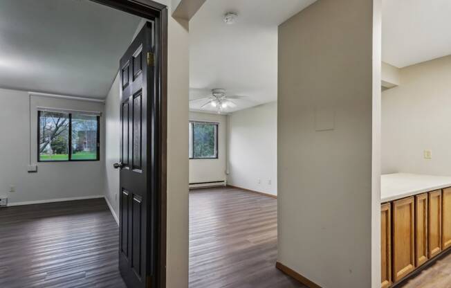 an empty living room with wooden floors and a black door