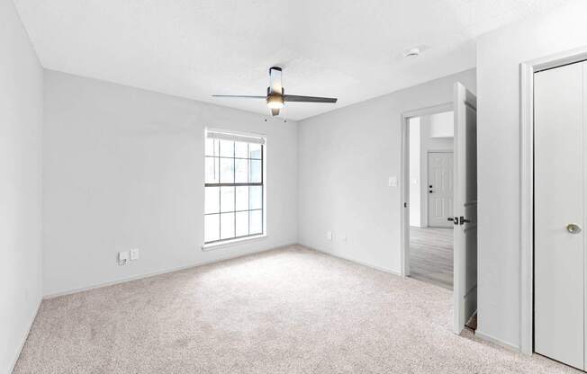 A room with a ceiling fan and a window.