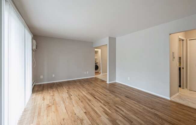 an empty living room with wood floors and grey walls