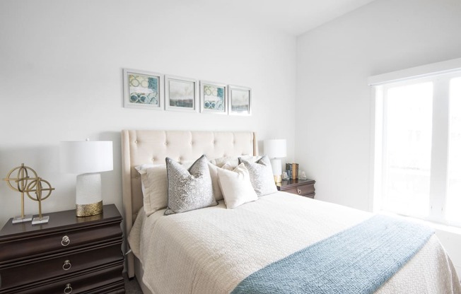 a bedroom with a bed and two nightstands and a window at 20 Midtown, Birmingham, Alabama