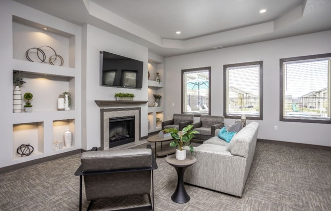 Spacious community room with fireplace, kitchen, and lounge seating.