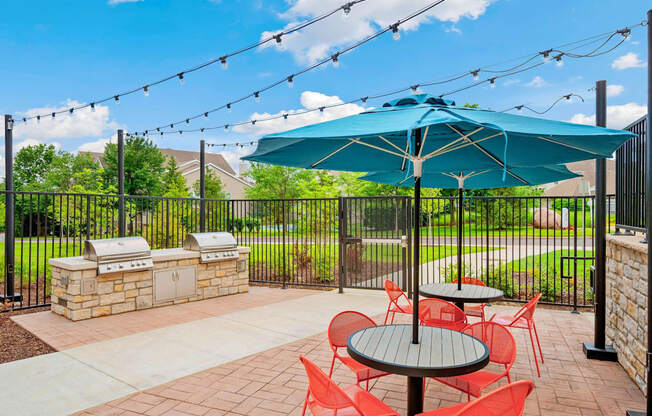 A patio with a table and chairs under a green umbrella.