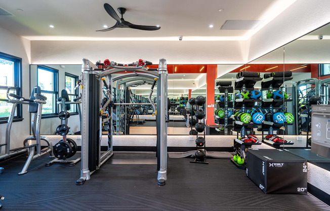 a gym with cardio equipment and weights on the wall