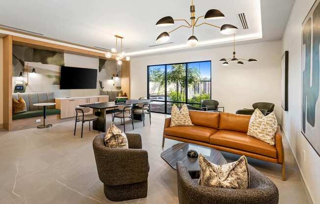 A modern living room with a brown leather couch and a glass coffee table.