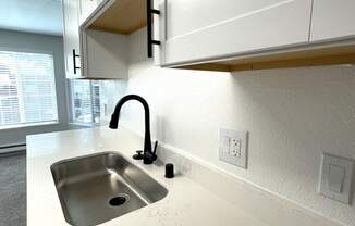 a kitchen with white cabinets and a sink