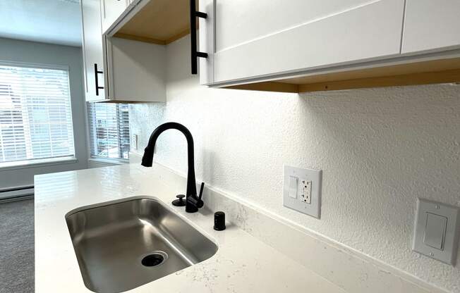 a kitchen with white cabinets and a sink