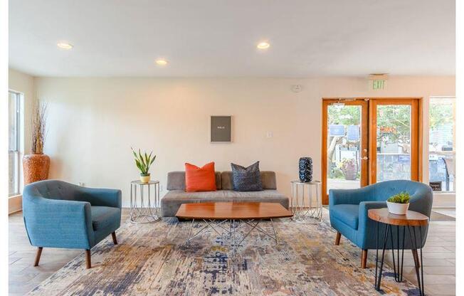 a living room with two blue chairs and a couch